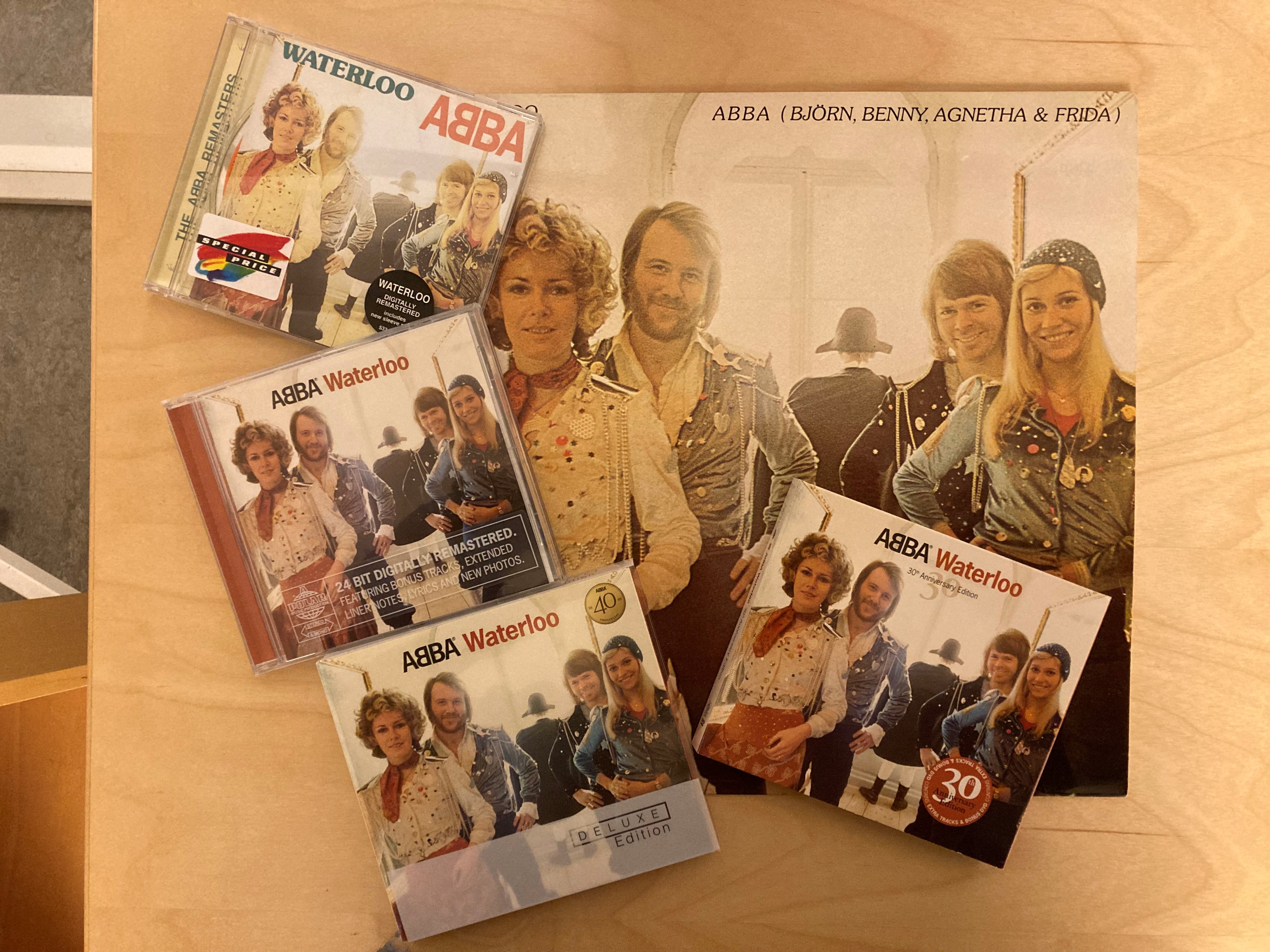 En lp-skiva och fyra cd-utgåvor av Waterloo. På omslagen syns två män och två kvinnor i förgrunden, i bakgrunden syns en gestalt i Napoleonhatt bakifrån.